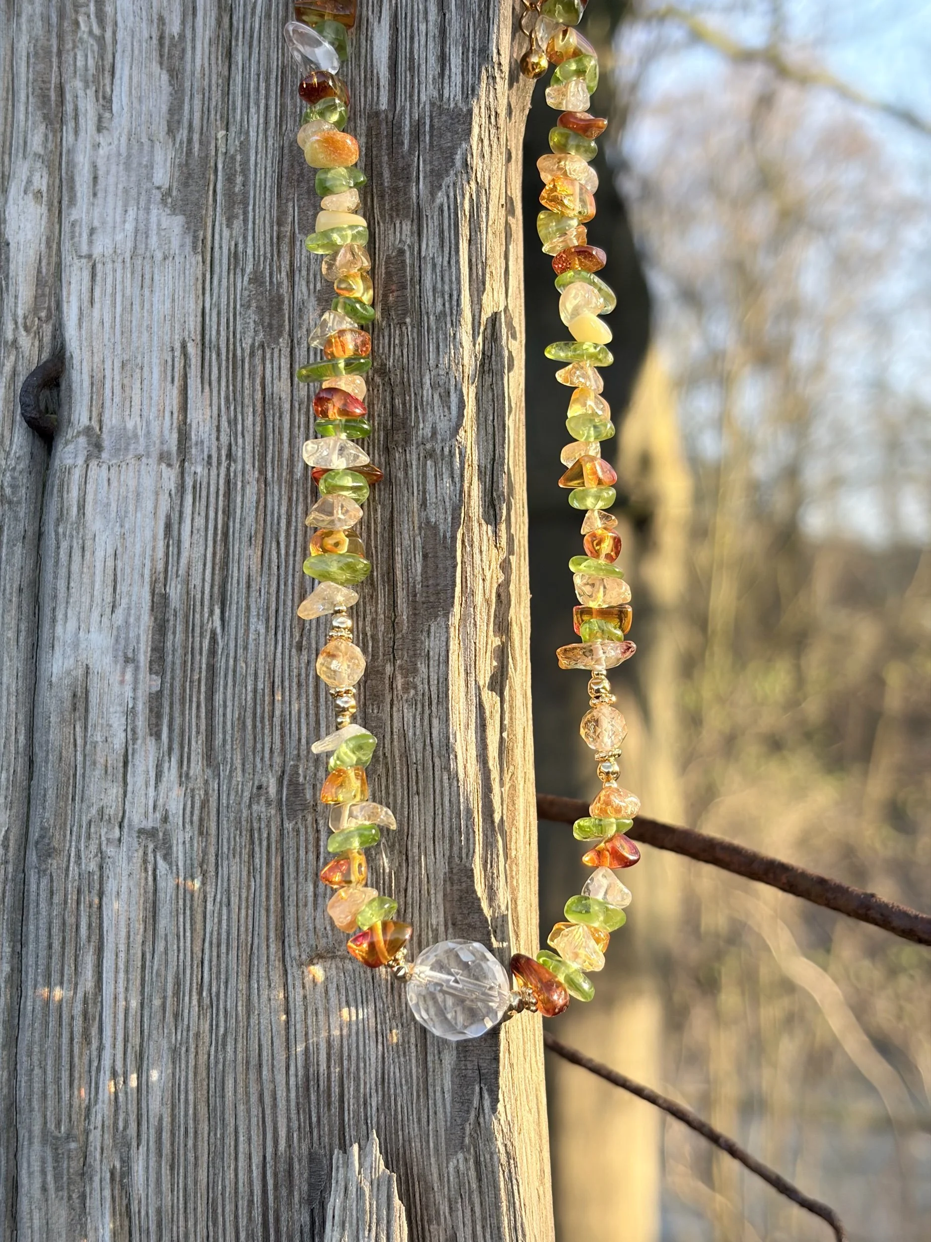 Edelsteinkette SOLARA mit Bergkristall, Citrin und Bernstein im Sonnenlicht auf Holz fotografiert