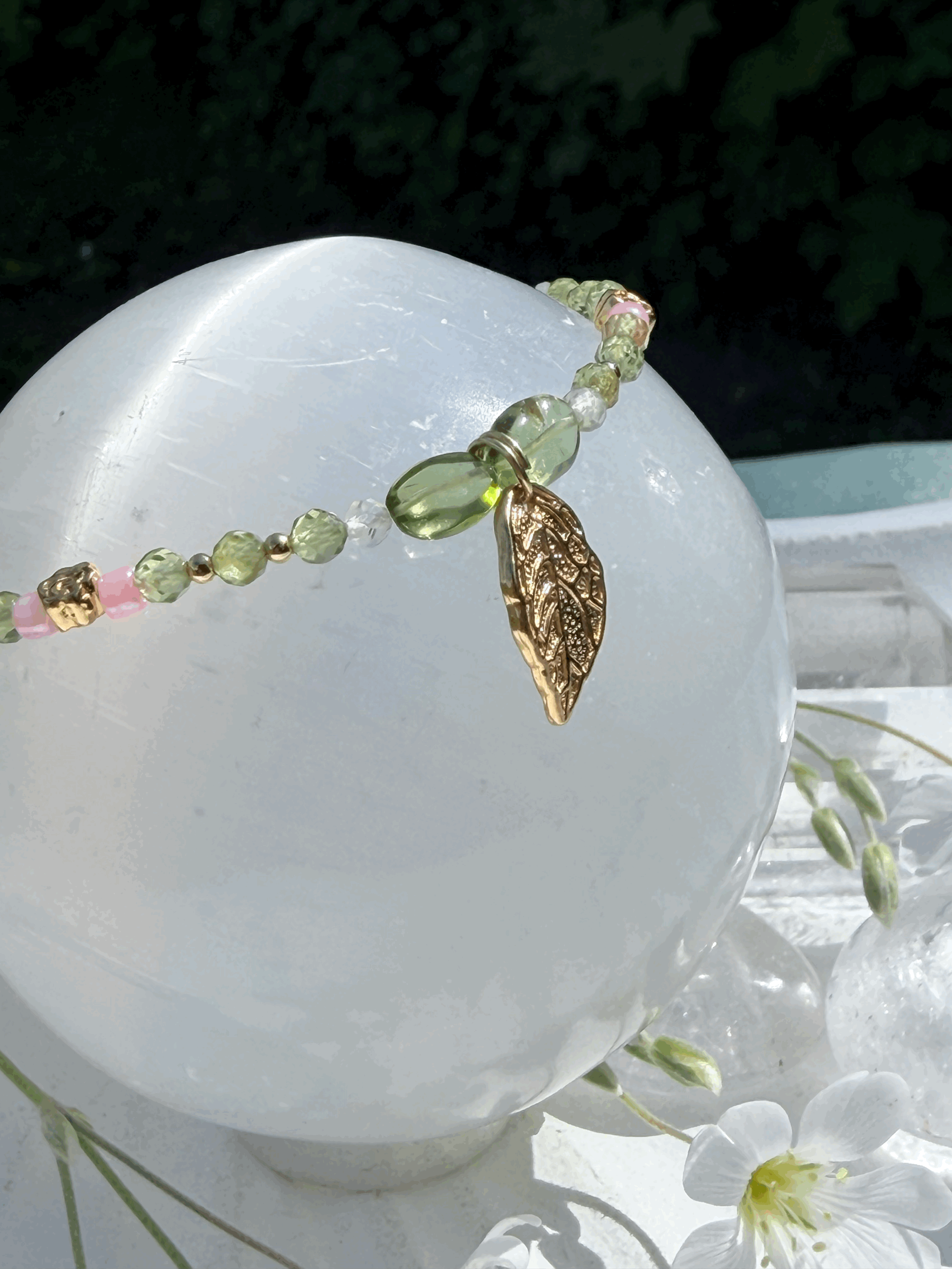 Detailansicht des vergoldeten Armbands mit Peridot und Prenit auf Kristallkugel