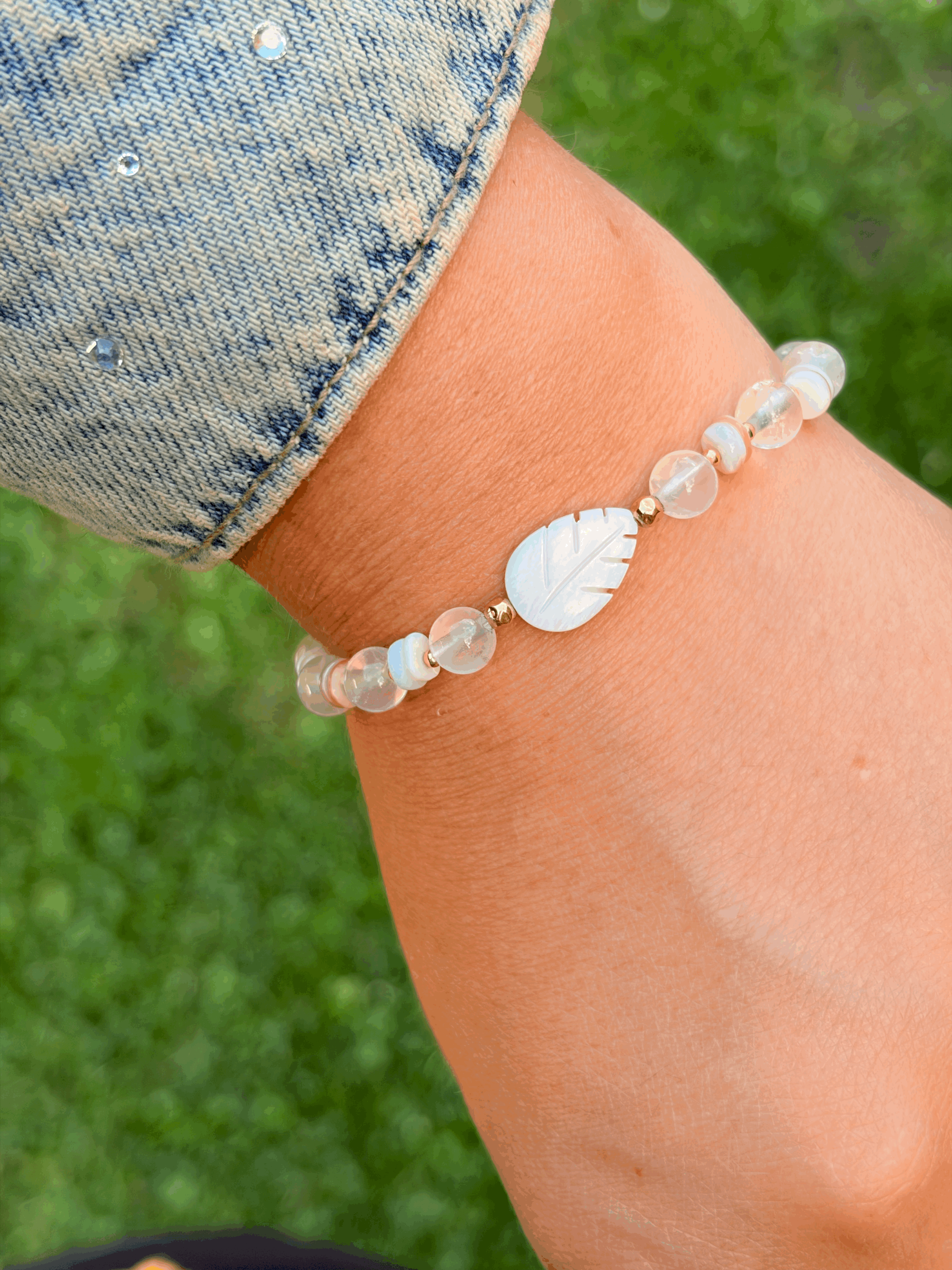 Handgefertigtes Perlmutt Armband mit Rosenquarz und Feder-Anhänger getragen