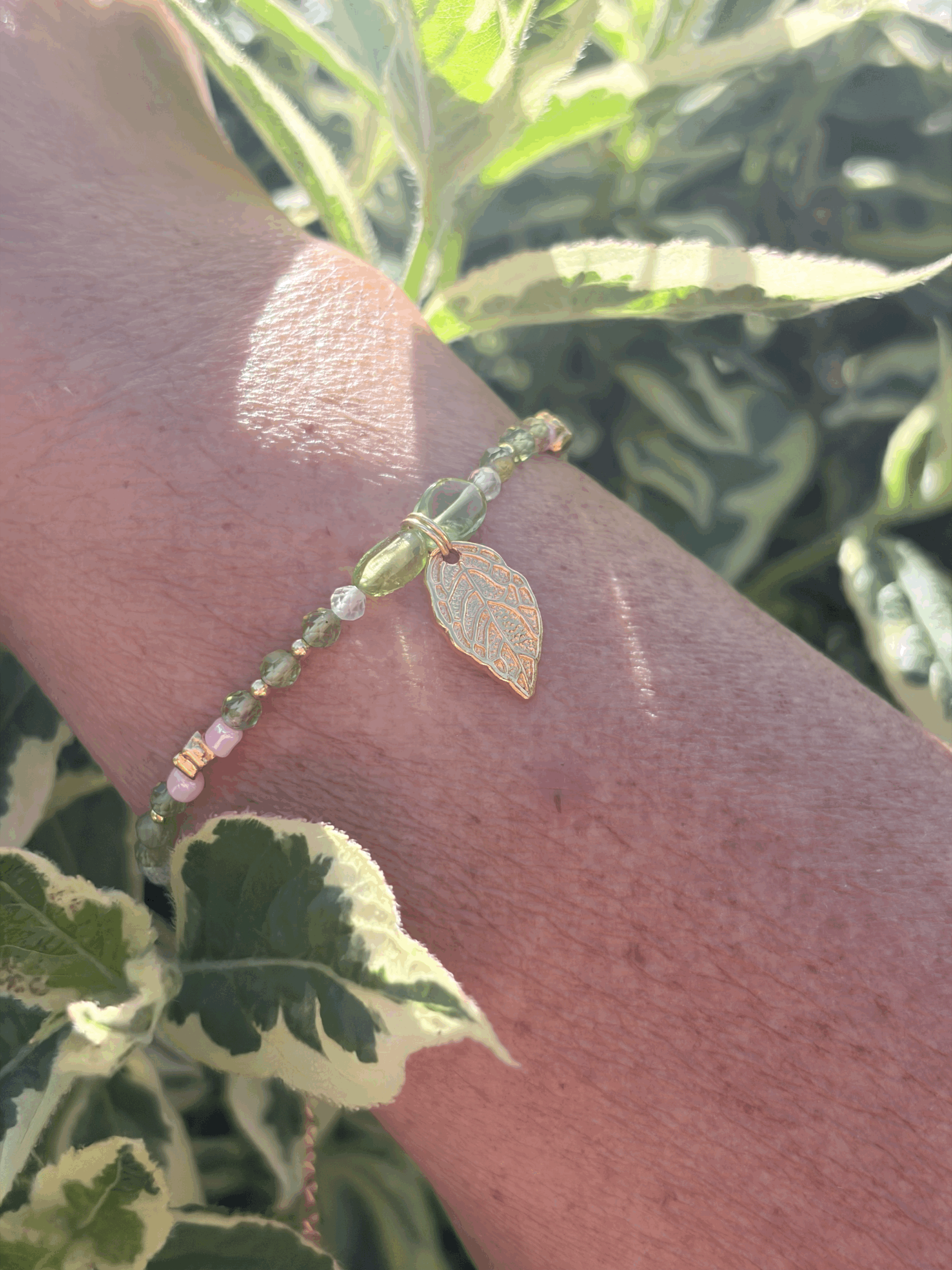 Handgefertigtes Peridot Armband mit goldenen Blüten und Prenit getragen