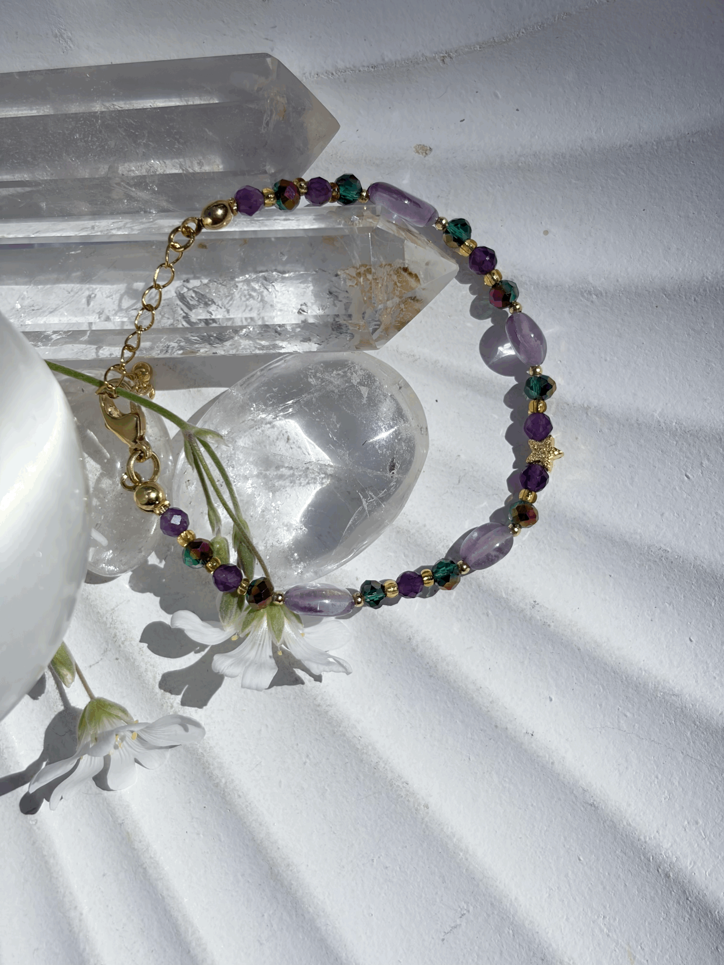 Stellara Armband mit Amethyst und vergoldeter Sternperle auf Kristallkugel präsentiert