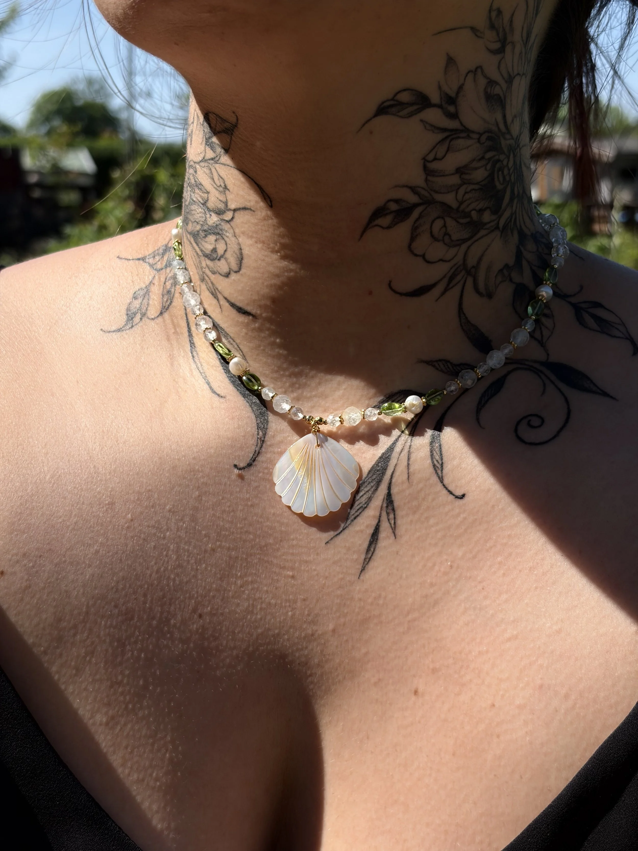 Handgefertigte Edelsteinkette MIREYA mit Peridot, Natur-Topas und Perlmutt-Muschel getragen am Hals