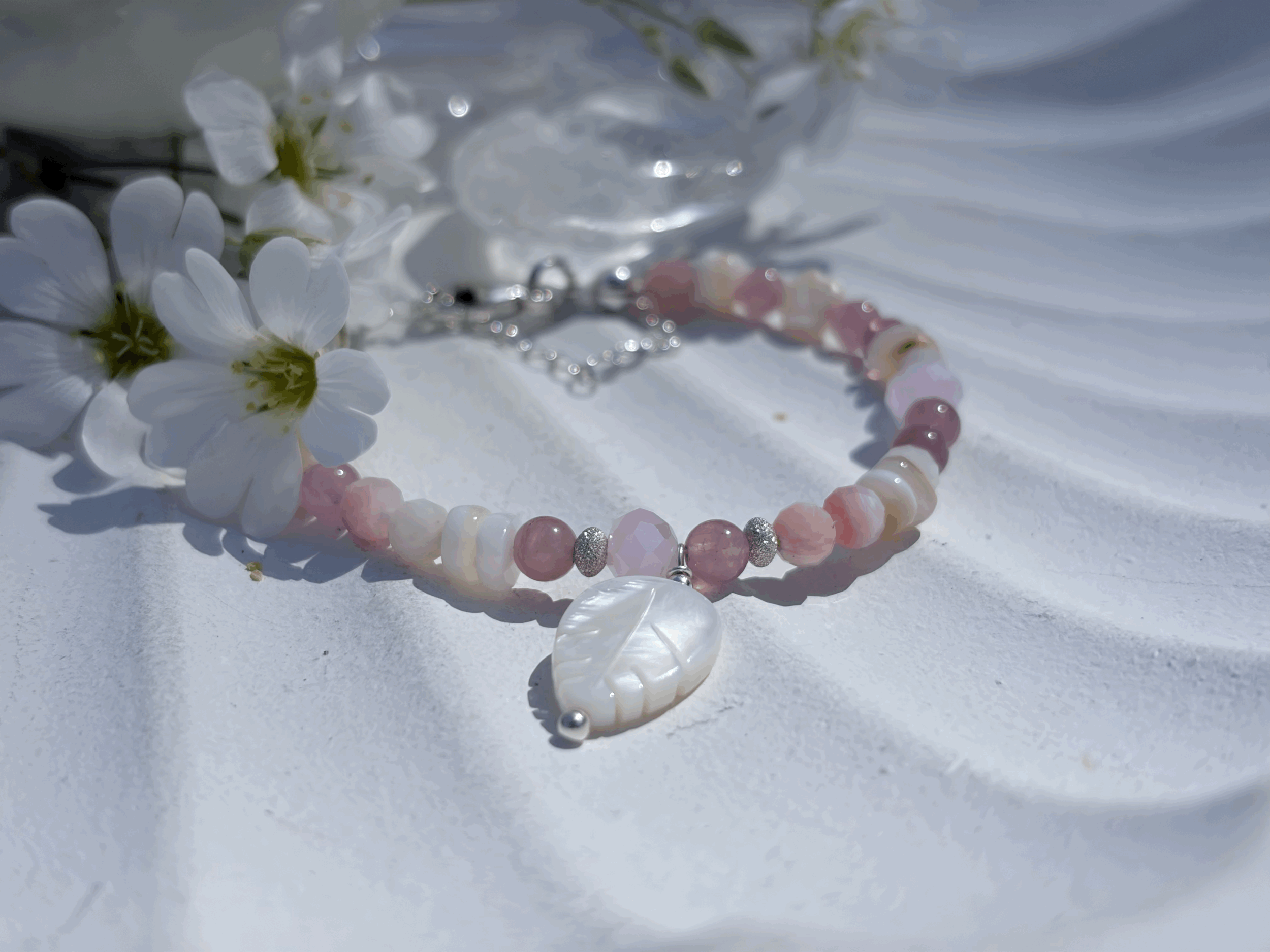 Detailaufnahme der Perlmuttfeder und facettierten Pinkopalperlen im Avelina Armband
