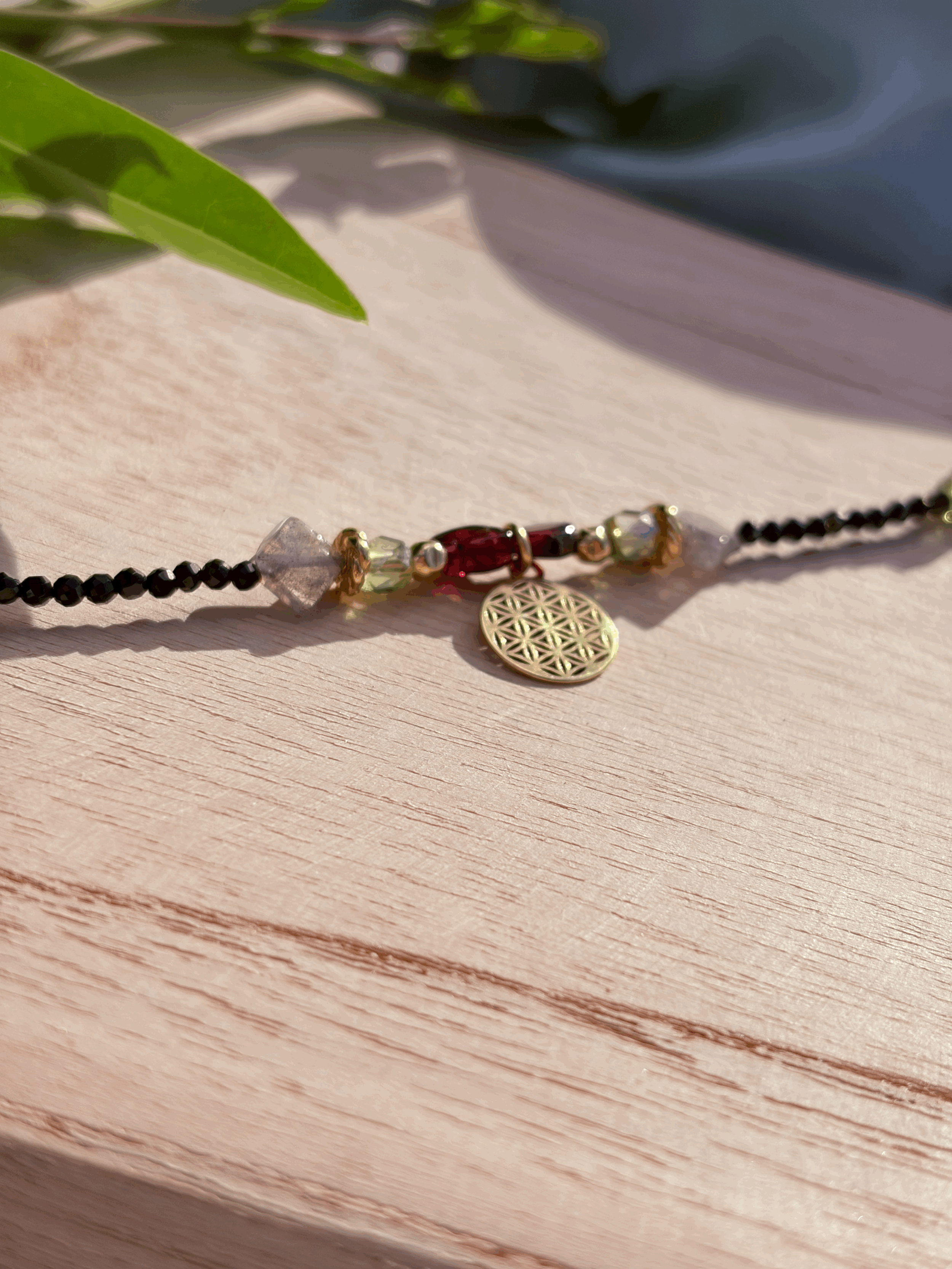 Detailaufnahme der Granatperlen und Blume des Lebens im Veridia Armband