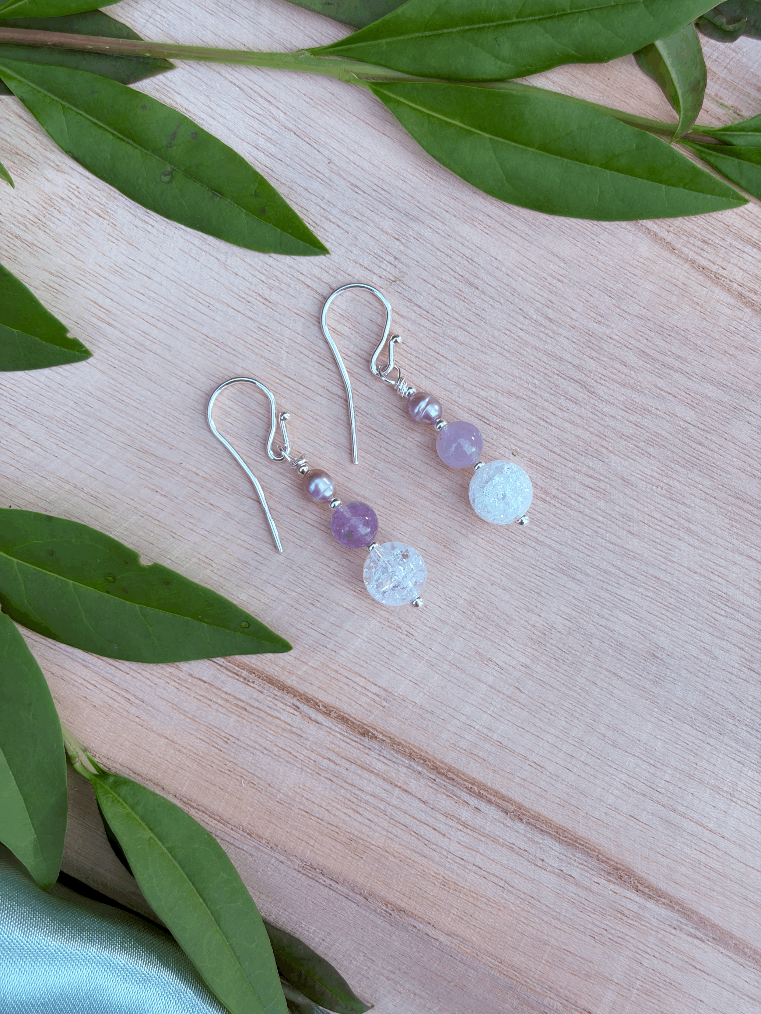 Lavendelamethyst Ohrringe mit Bergkristall und Süßwasserperle auf Holz fotografiert