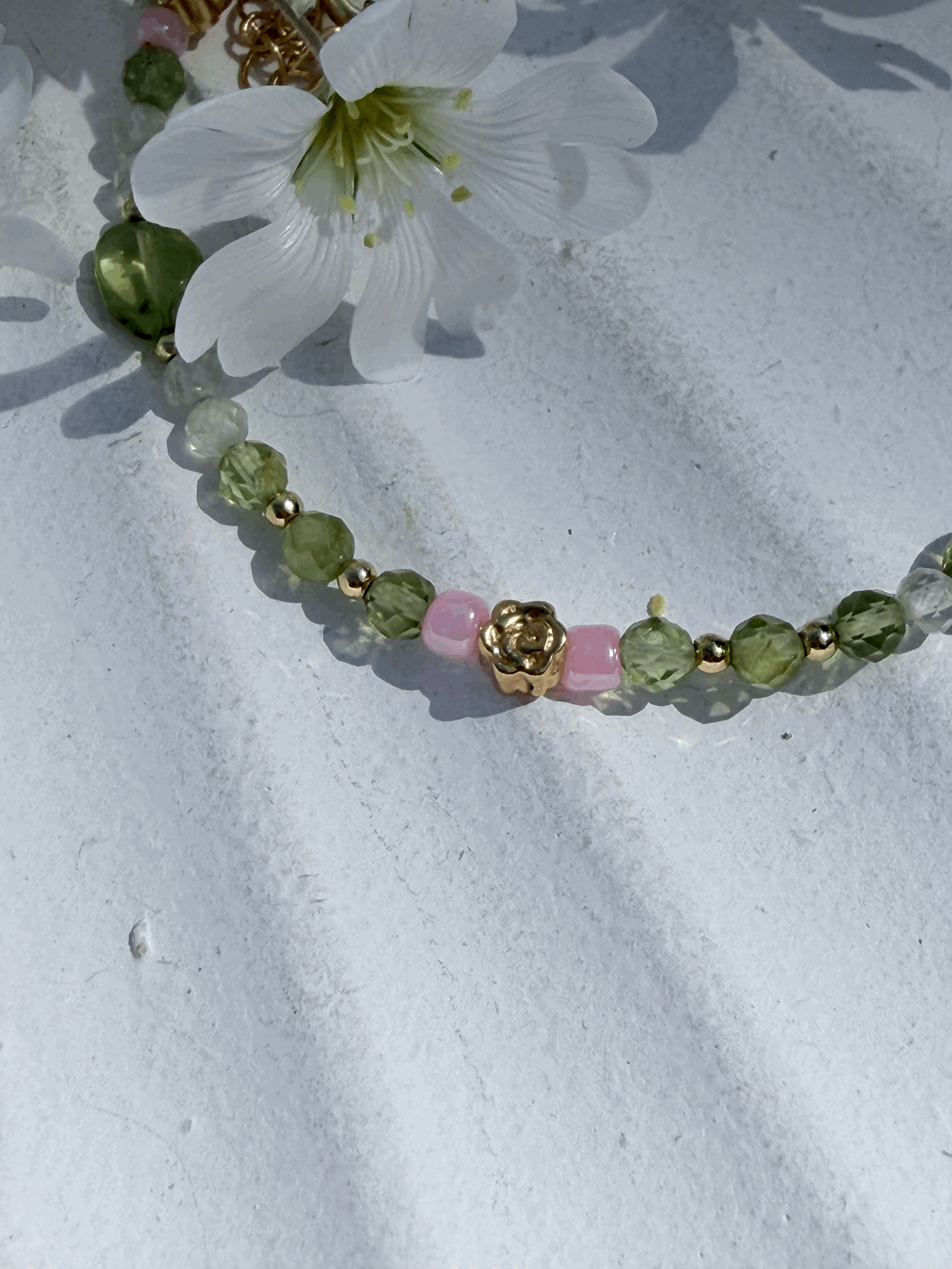 Detailaufnahme der Peridot-, Prenit- und Blütenelemente im ROSELYA Armband
