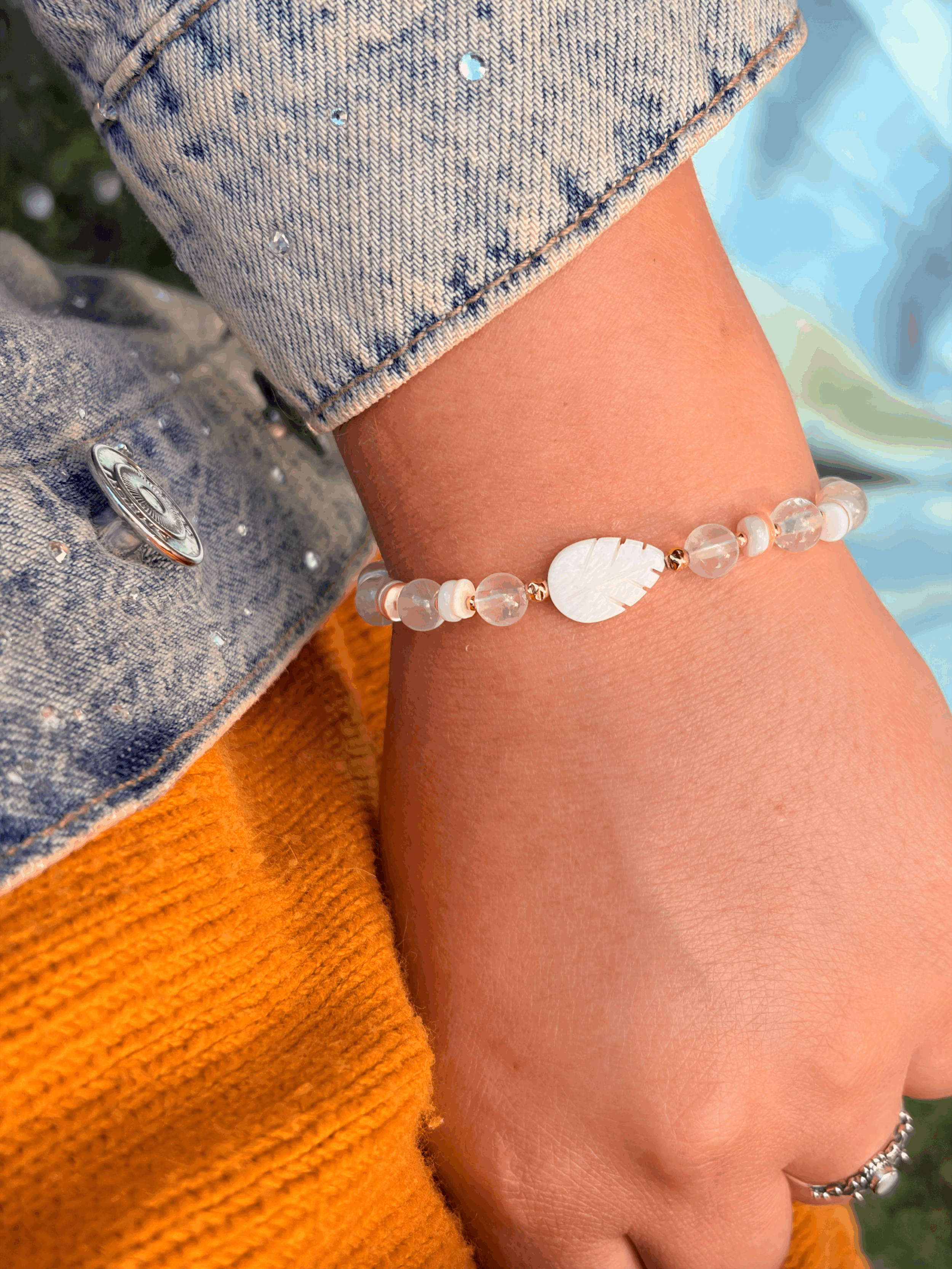AWENIA Rosenquarz Armband mit schimmernder Perlmuttfeder getragen am Handgelenk