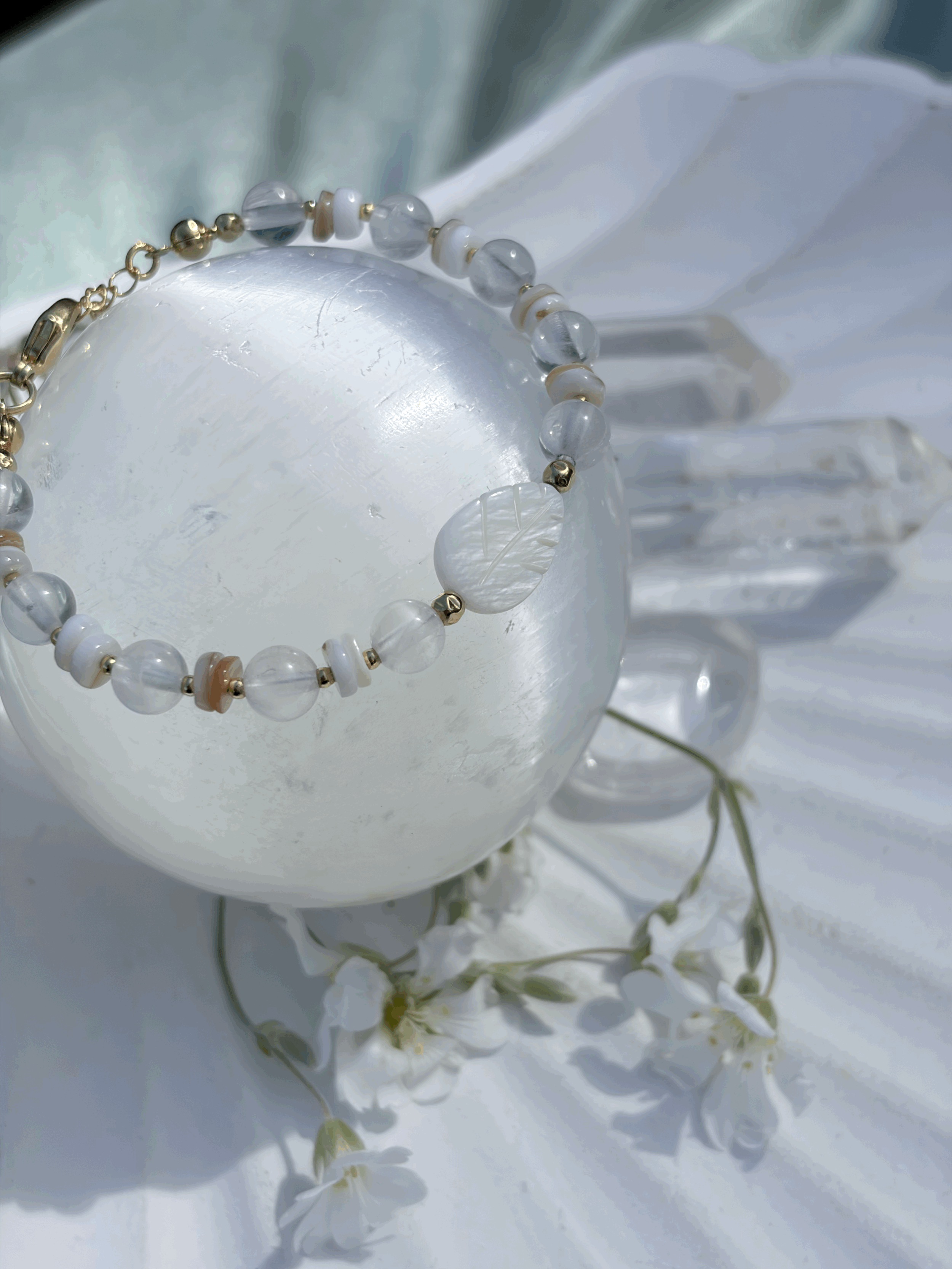 AWENIA Edelstein Armband mit Rosenquarz und Perlmutt auf einer Kristallkugel