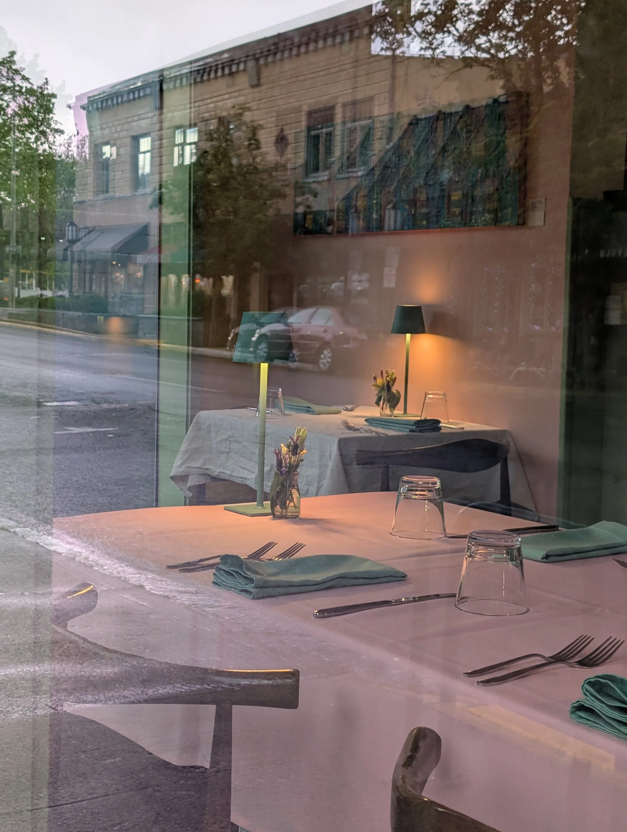 Looking in at the dining experience at Nous. Muted light, soft colors, tablecloths, elegant but unpretentious place settings. A cozy table