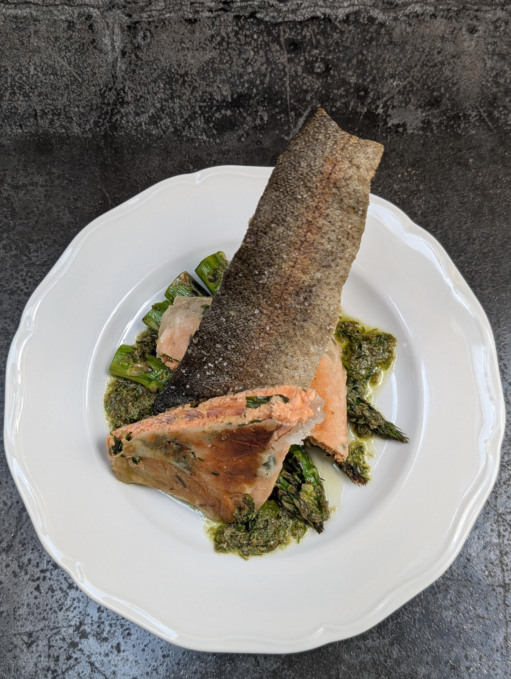 Wild Caught salmon plated elegantly with fresh, local asparagus and crispy trout skin