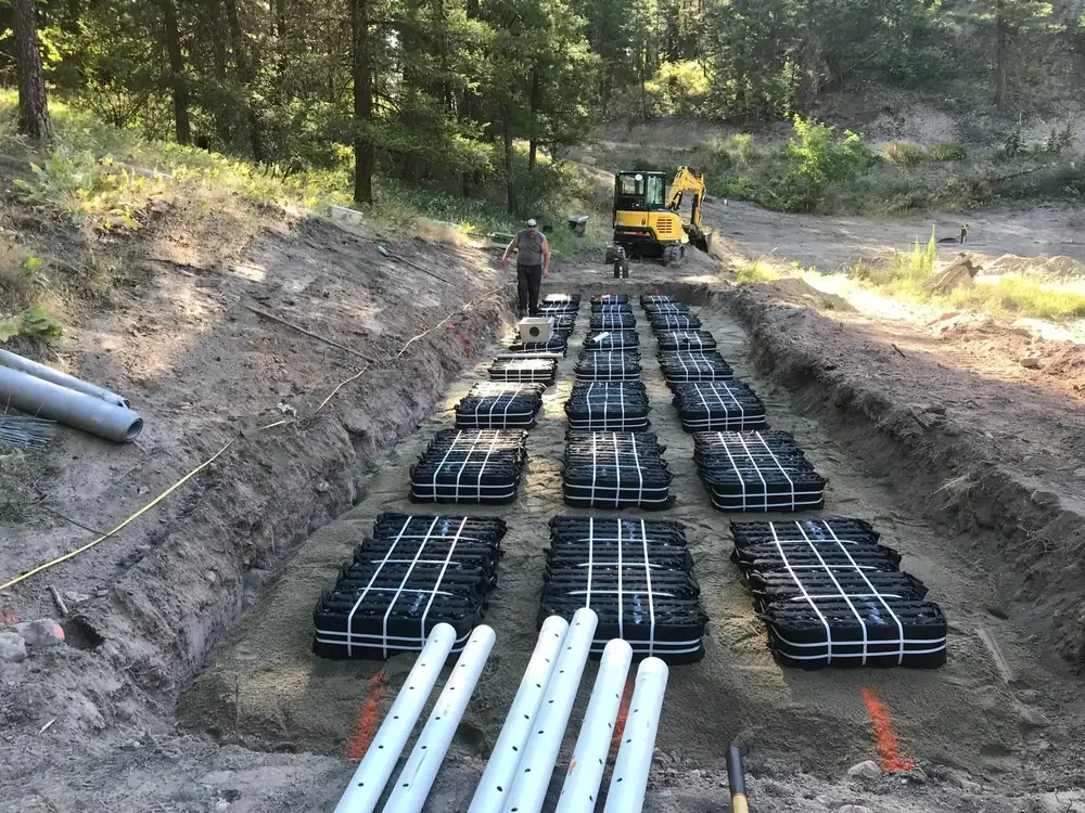 Rows of septic field chambers and drainage pipes being installed in an excavated area during septic site preparation in the South Okanagan, BC.