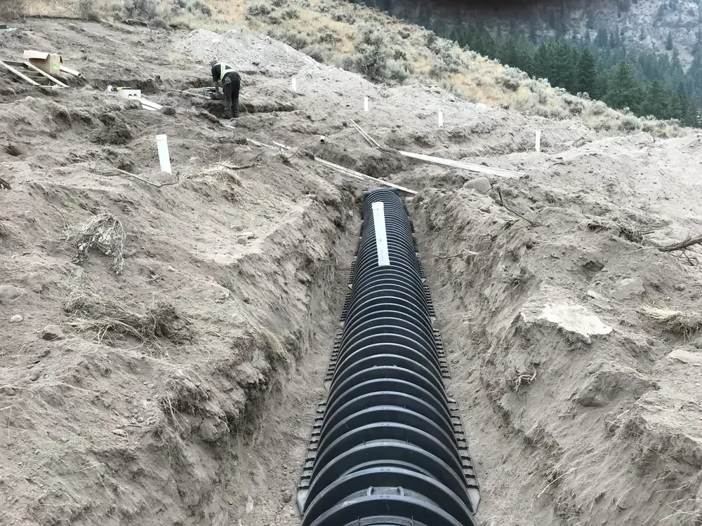 Septic field installation project featuring an excavated trench and underground drainage chambers on a rural property in the South Okanagan, BC.