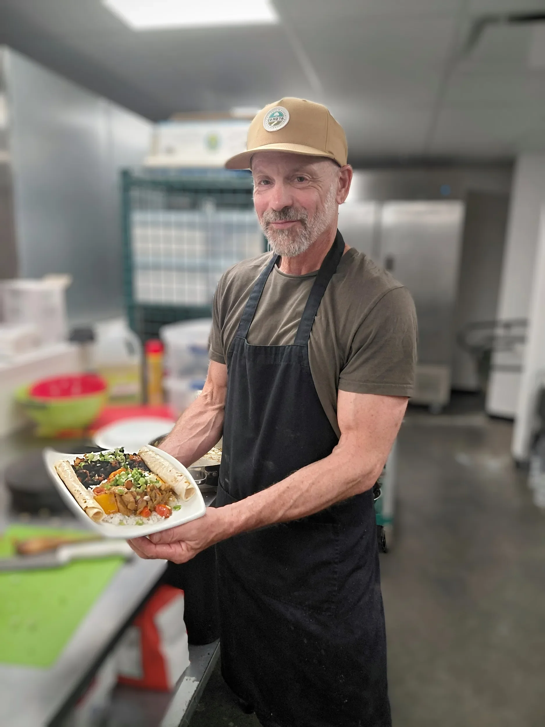 Adult student holding his meal he made during the creative cooking challenge