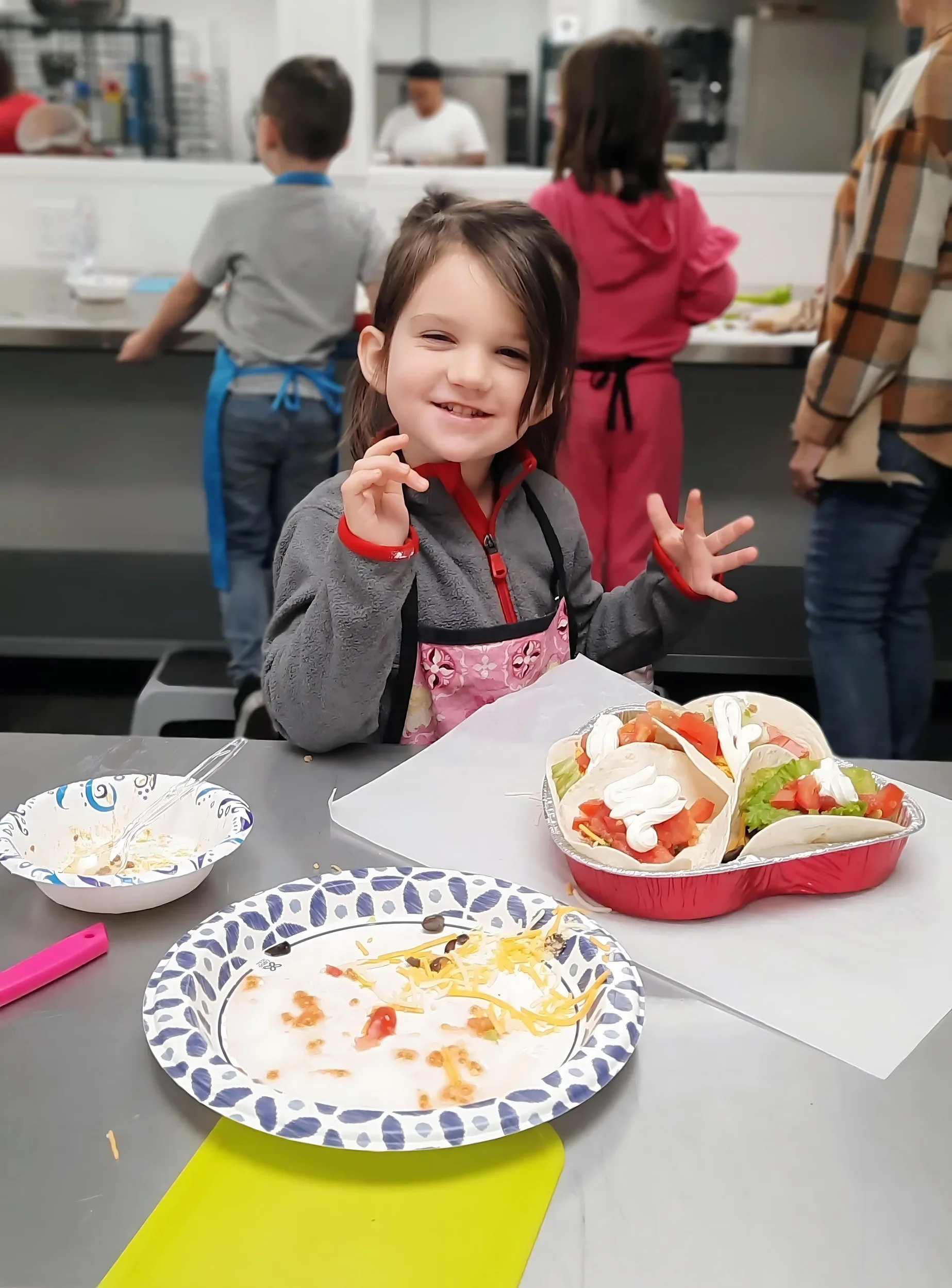 Young child with her tacos she made during a mini chef cooking class in Columbia, MO