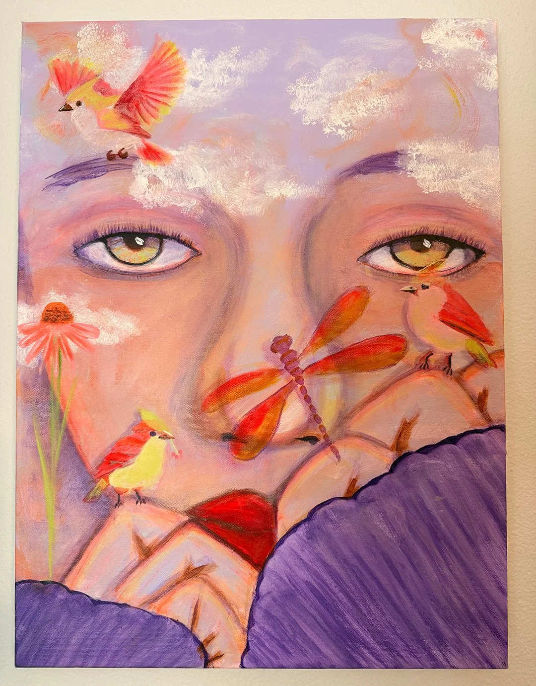 A surreal portrait of a person's face with yellow eyes, surrounded by colorful birds, dragonflies, flowers, clouds, and purple leafy elements, blending realism with fantasy.