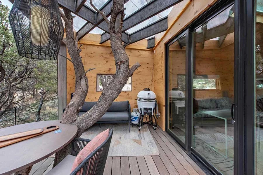 Elevated outdoor deck surrounded by trees at a Colorado treehouse rental