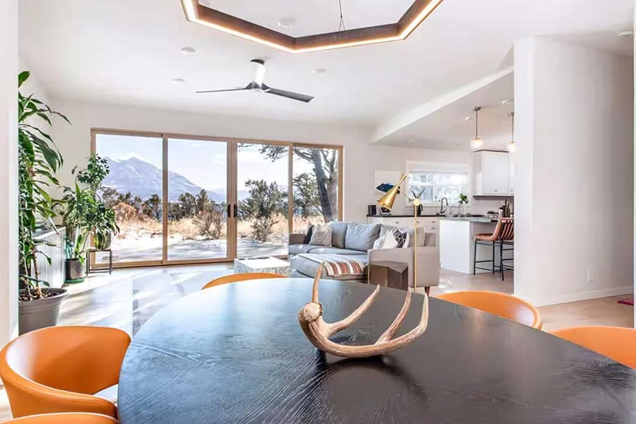 Modern mountain living room with comfortable furnishings and expansive windows at High West House