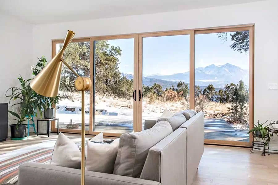 Modern mountain living room with comfortable furnishings and expansive windows at High West House