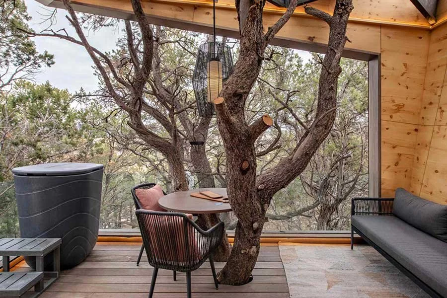 Elevated outdoor deck surrounded by trees at a Colorado treehouse rental