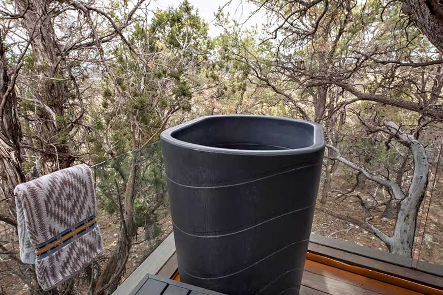 Elevated outdoor deck surrounded by trees at a Colorado treehouse rental