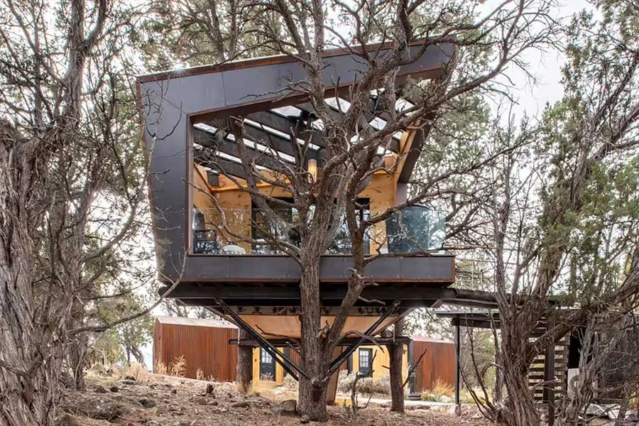 Elevated outdoor deck surrounded by trees at a Colorado treehouse rental