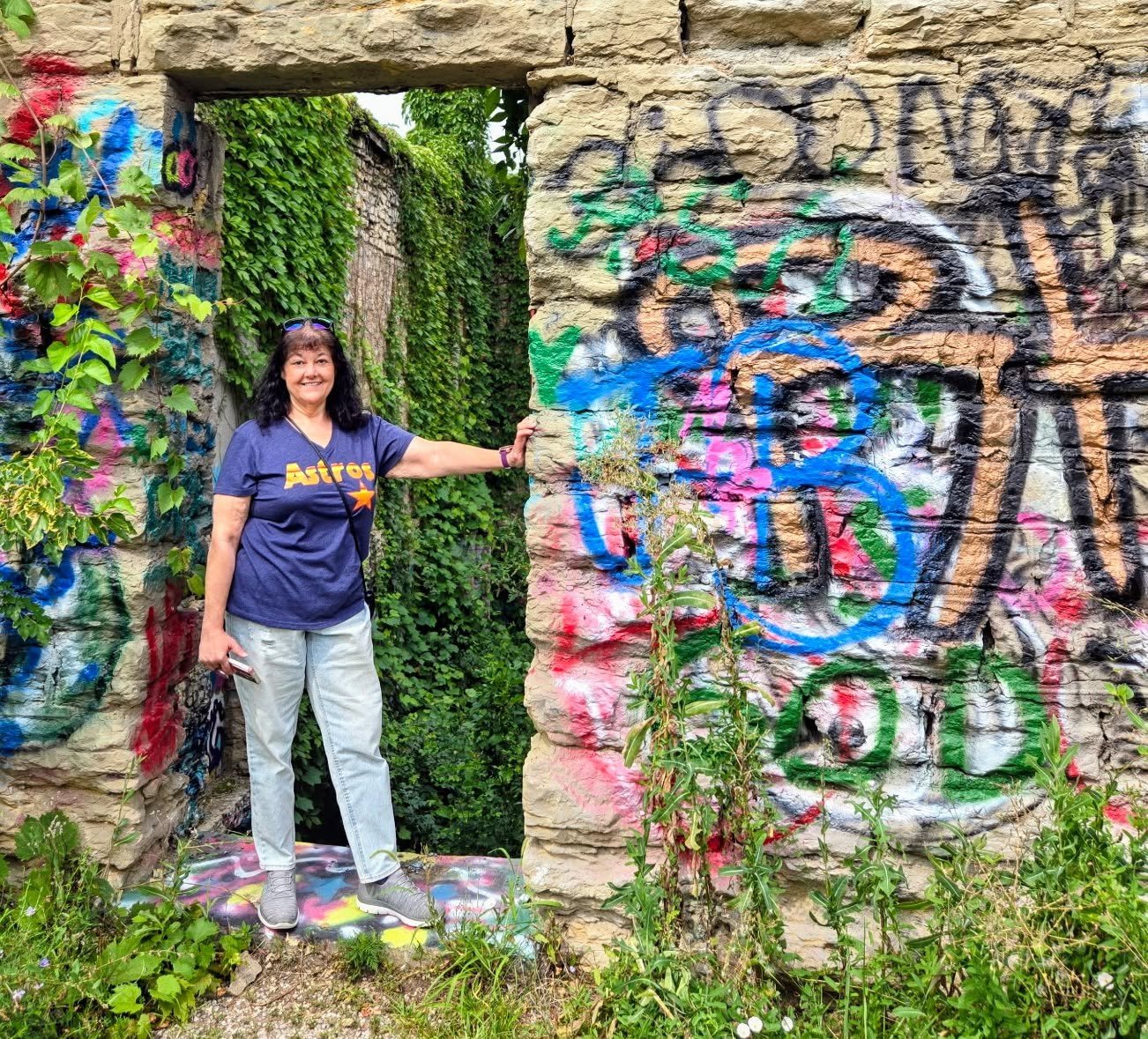 Tootie standing next to a wall with lots of colors, it was an abandoned castle in Kansas City , MO