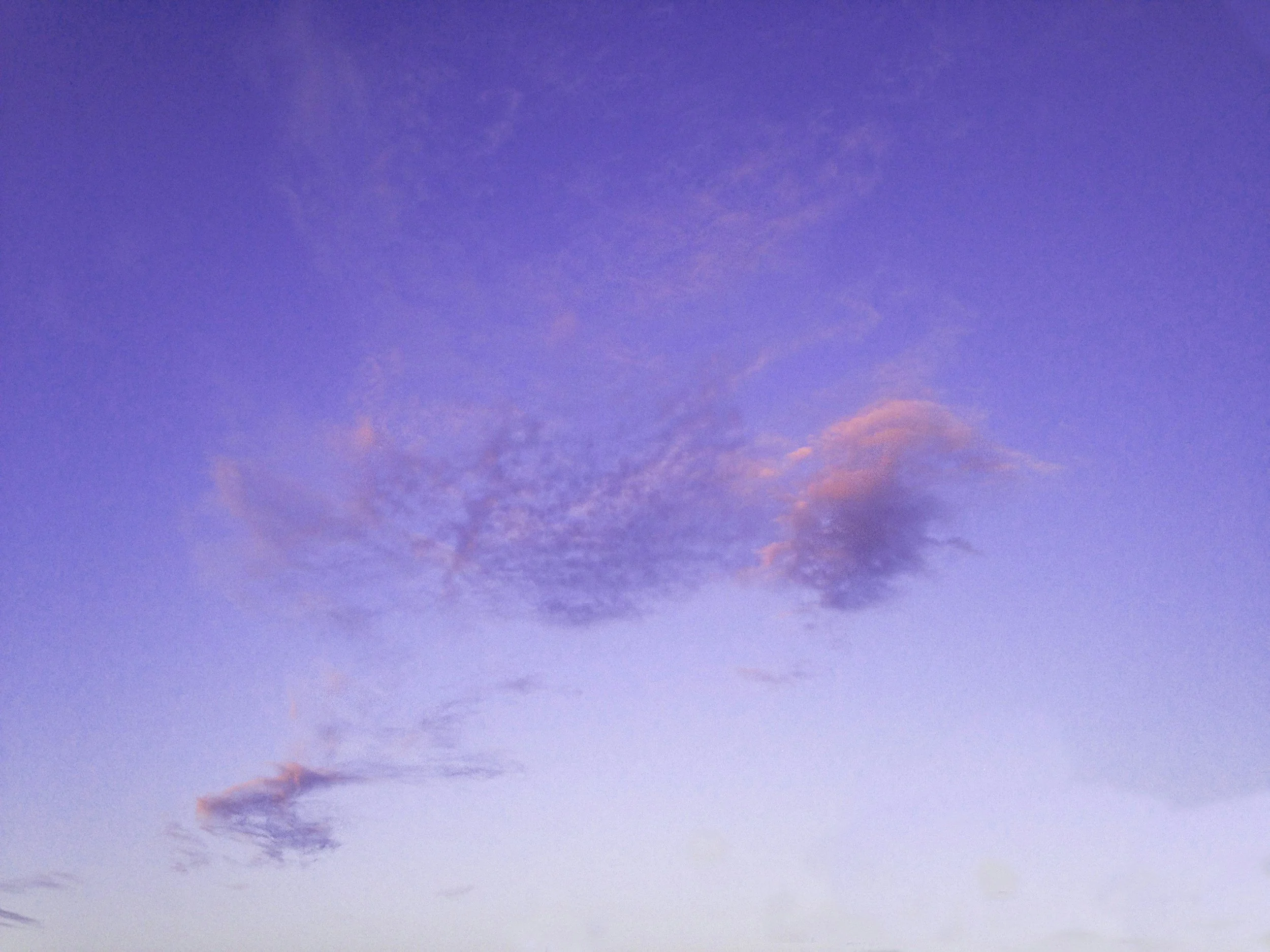 A sky during sunset or sunrise with blue, purple, and pink clouds.