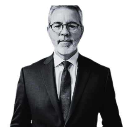 Black and white portrait of a middle-aged man with glasses, gray hair, and a beard, wearing a suit and tie.