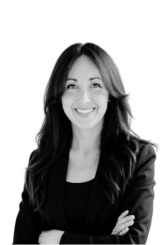 Smiling woman with long wavy hair wearing a blazer, facing forward with arms crossed.