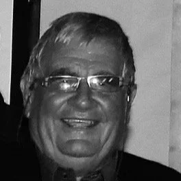 Smiling middle-aged man with glasses and short hair.