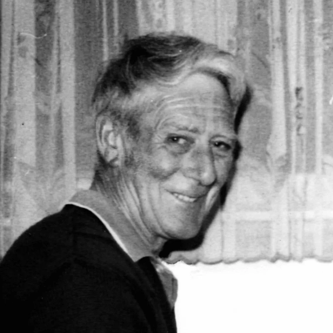 Black and white photo of a smiling older woman with short hair.