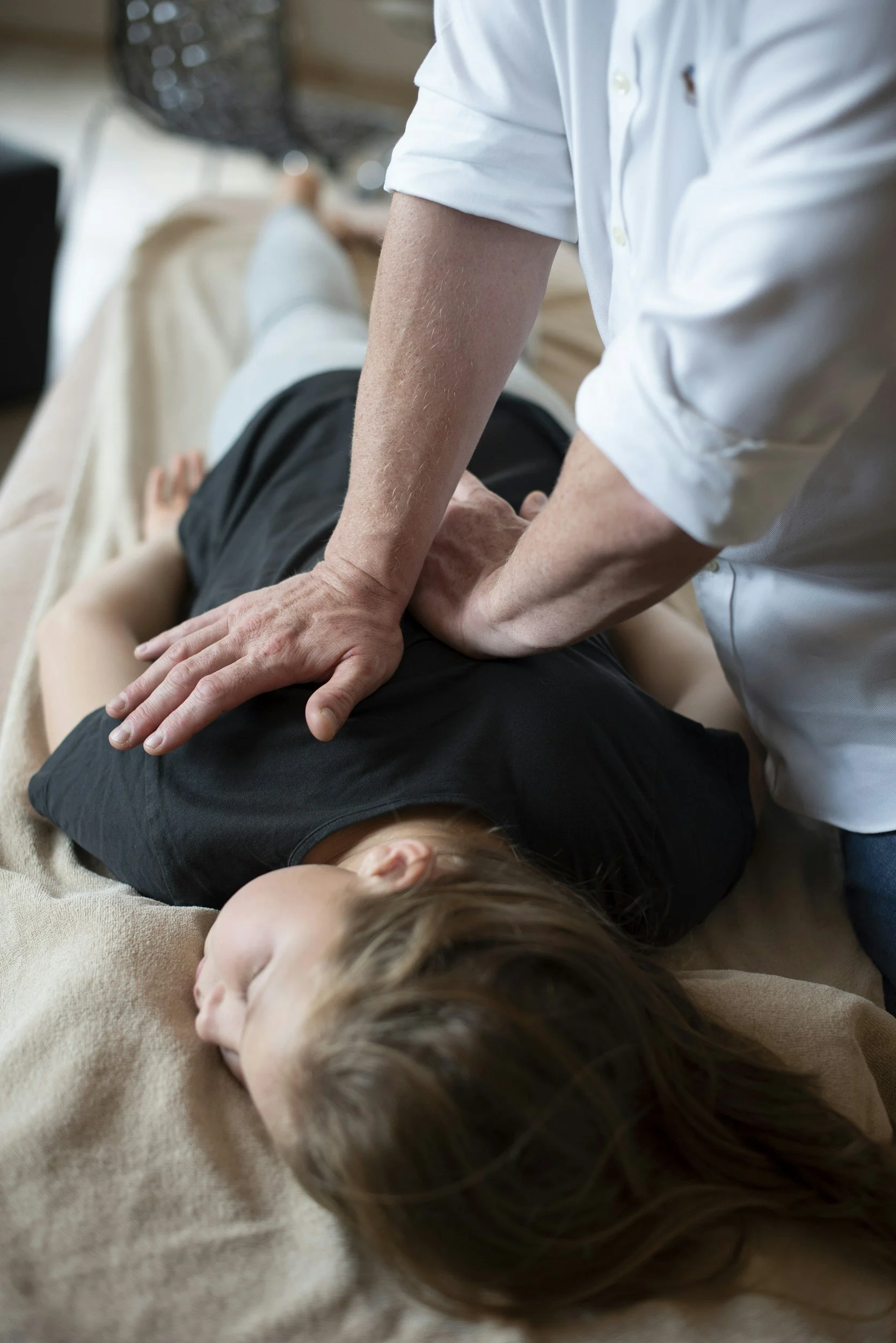 A gentle chiropractic adjustment being performed on young person.