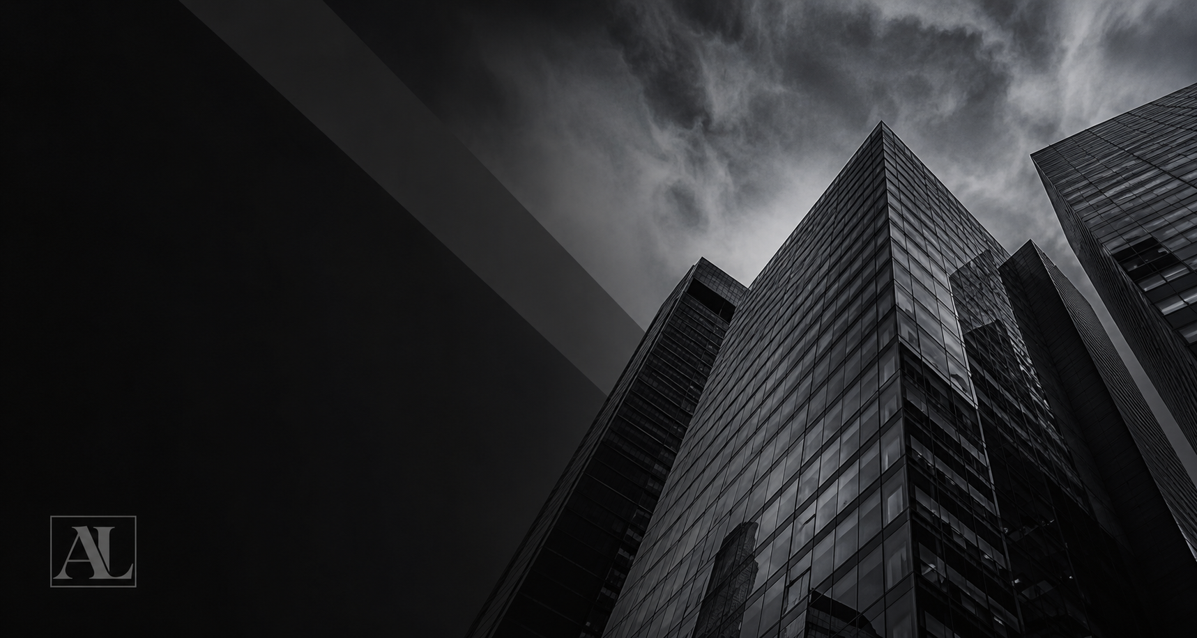Low-angle view of modern glass skyscrapers under a cloudy sky.