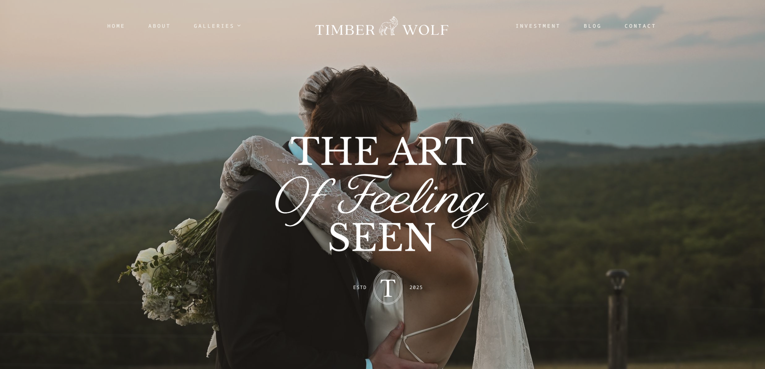 A couple dressed in wedding attire kissing outdoors during sunset, with scenic hills in the background.
