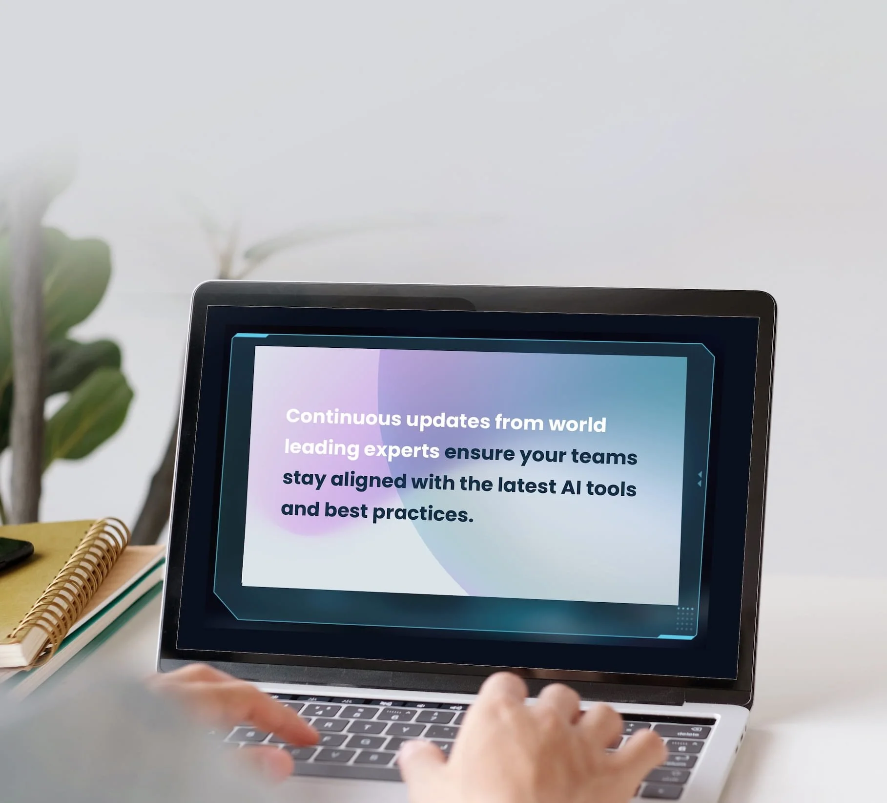 Close-up of a person using a laptop with a screen displaying text about AI tools and beta features. The background shows a plant, a spiral notebook, and a pen on a desk.