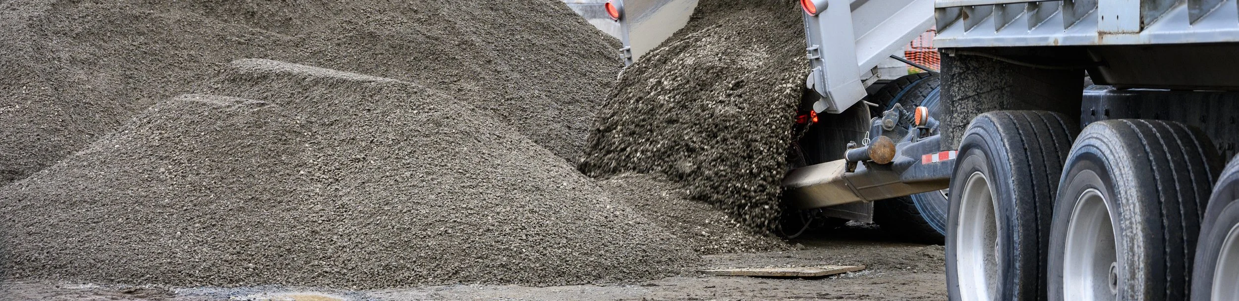 A dump truck unloading gravel or dirt.