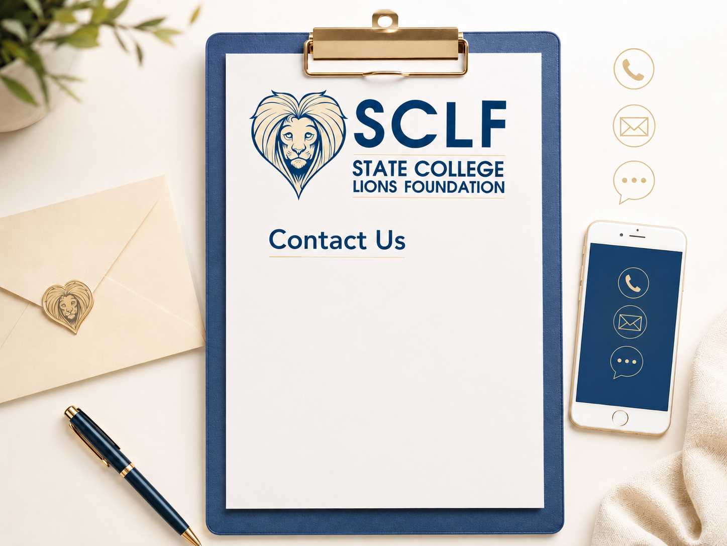 A clipboard with a sign for the State College Lions Foundation, featuring a lion logo and contact information. Surrounding items include an envelope with a lion sticker, a black and gold pen, a smartphone with contact icons, and a decorative cloth.
