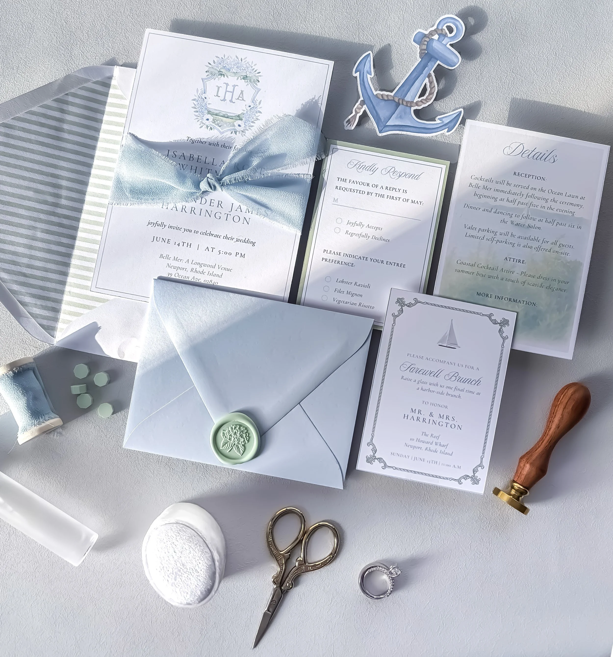 Wedding invitation, anchor sticker, small envelopes, skincare items, scissors, jewelry, rings, and a wooden handle.