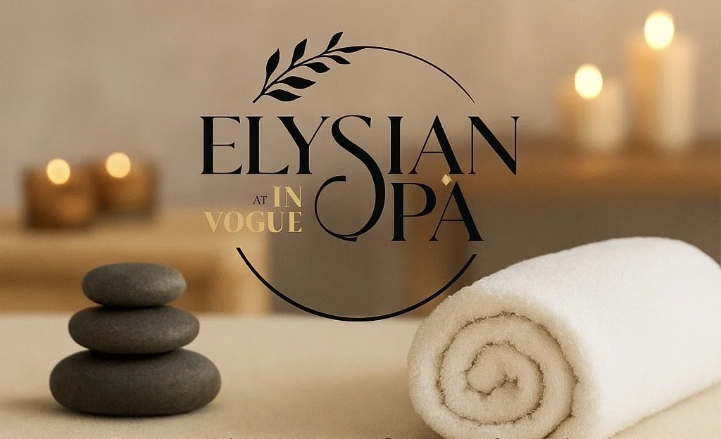 Spa setting with stacked black stones, a rolled white towel, and lit candles in the background with the text "Elysian at Vogue P."