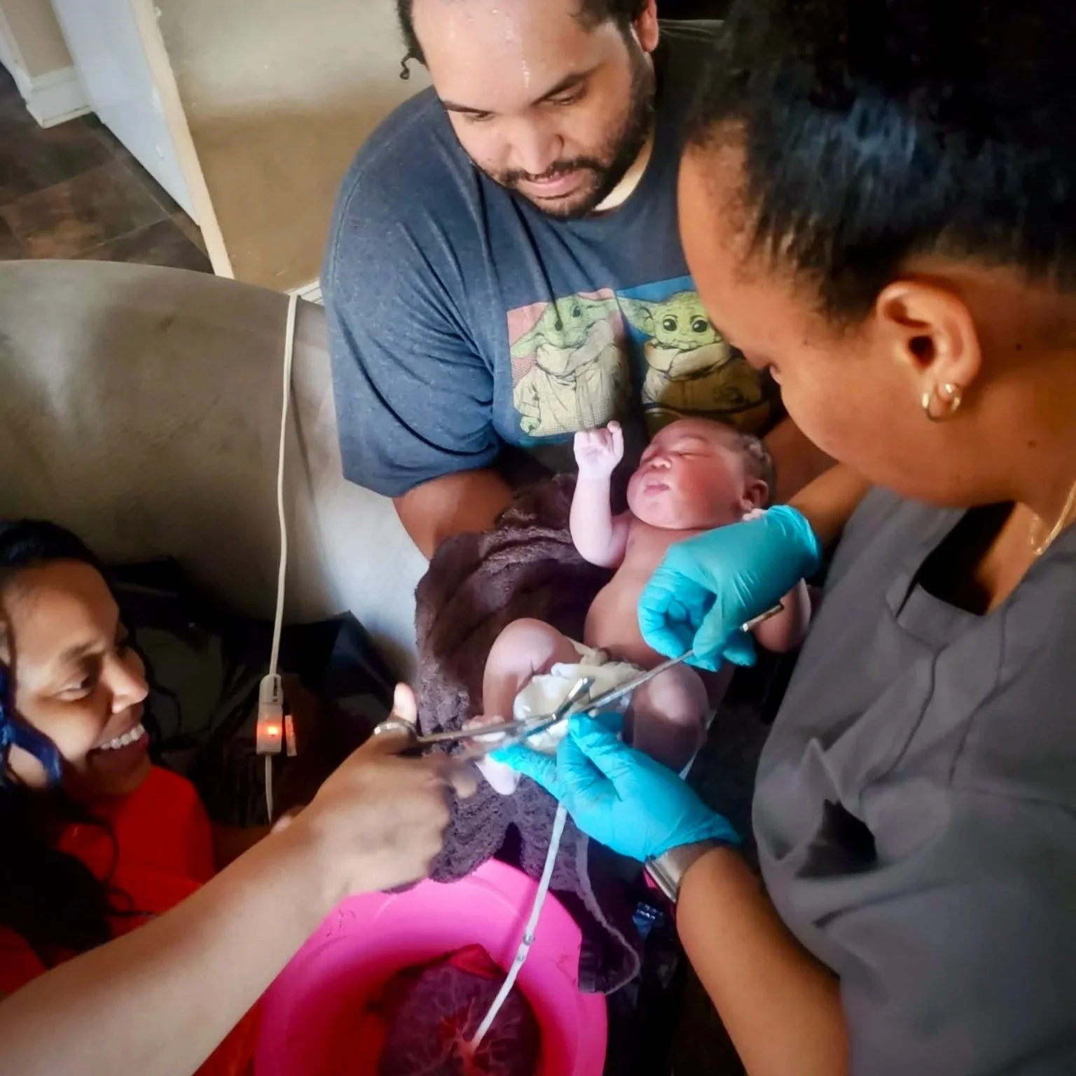 woman cutting the cord on newborn baby