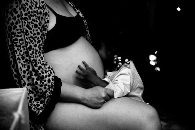 Woman in labor with little girl hugging belly