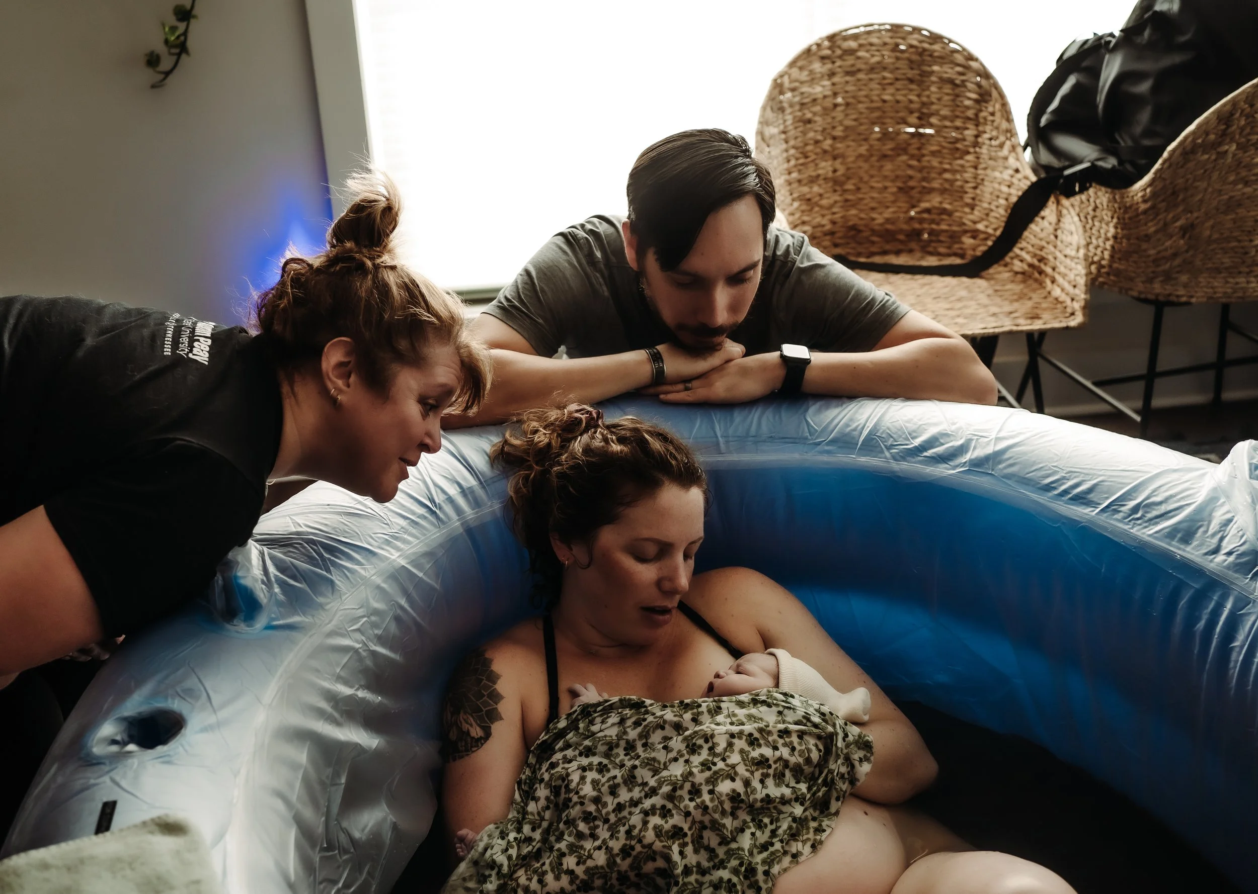 Woman in birth tub holding baby