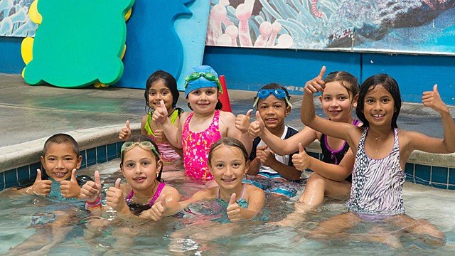 Young children in swimwear and goggles in a swimming pool celebrating a birthday pool party at Sutton Swim School serving families throughout Campbell, San Jose, Saratoga, and Los Gatos