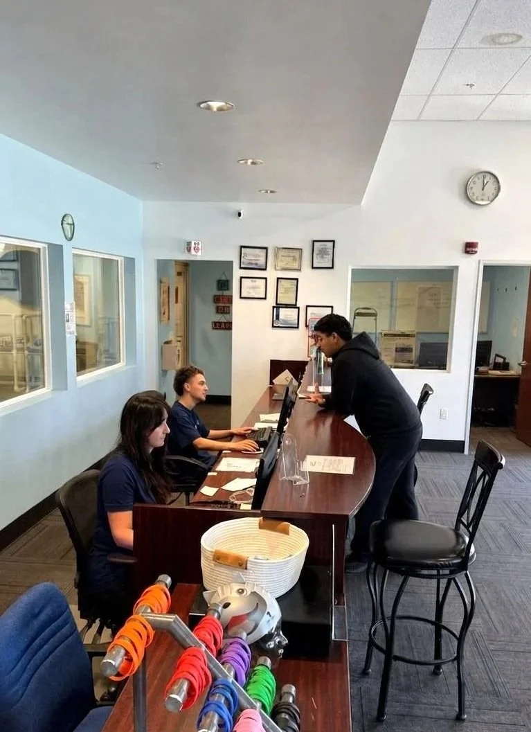Sutton Swim School front desk staff assisting families with lesson schedules in Campbell, CA