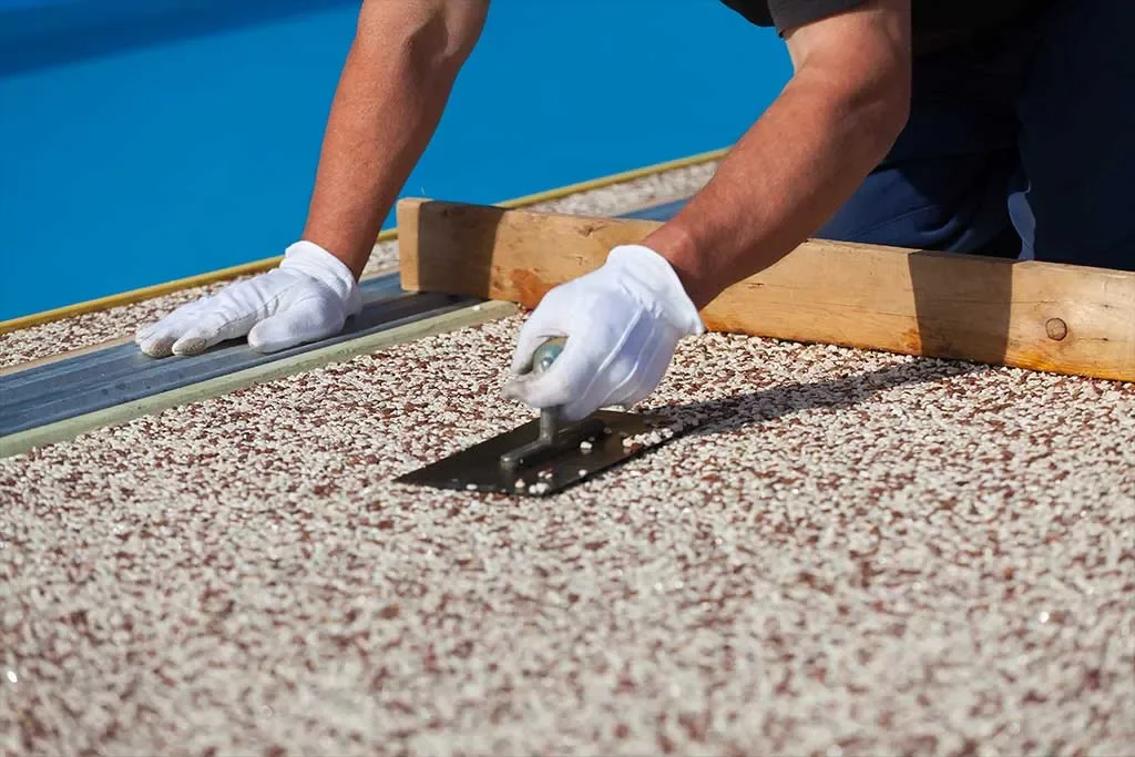 Person installing roof shingles with a trowel and straightedge.