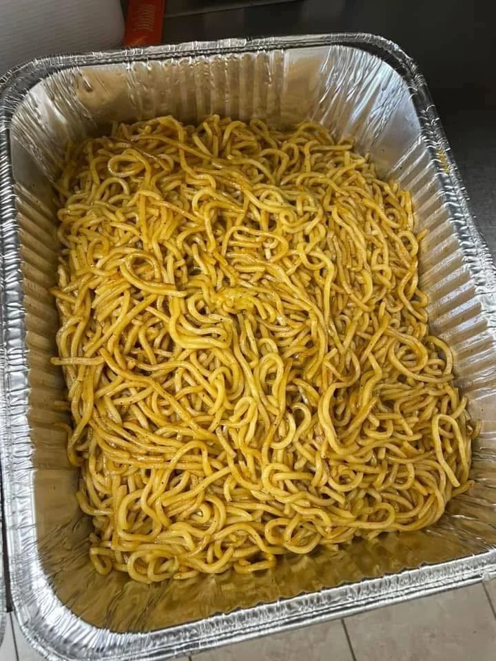 A rectangular aluminum tray filled with cooked Chinese-style yellow noodles.