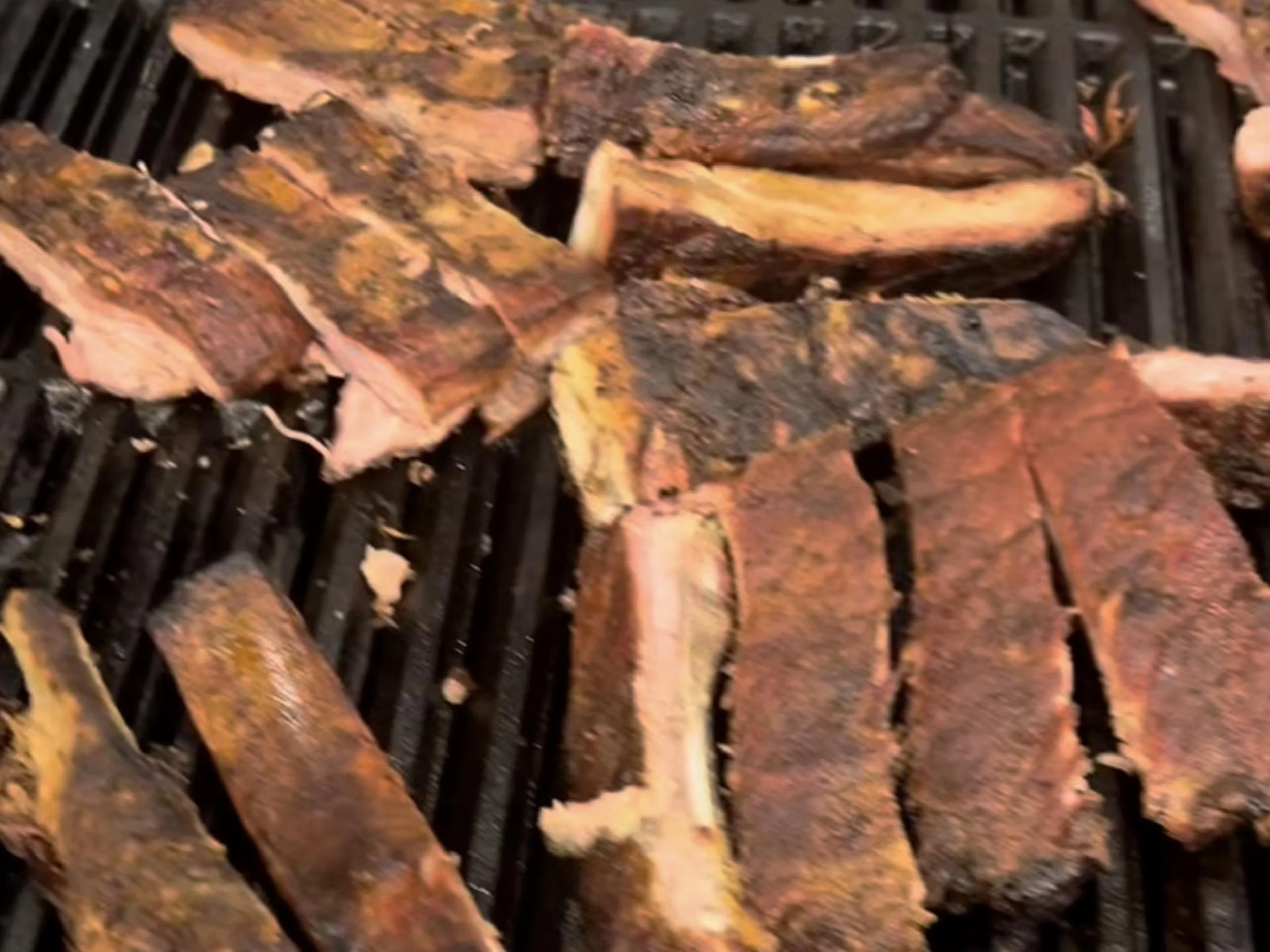 Close-up of shredded, cooked beef on a grill.
