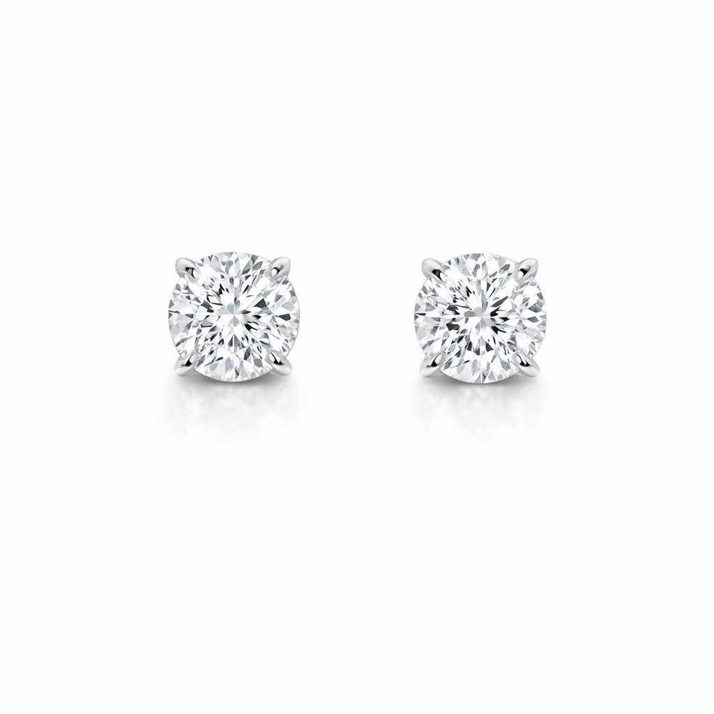 A pair of diamond stud earrings with silver settings on a white background.