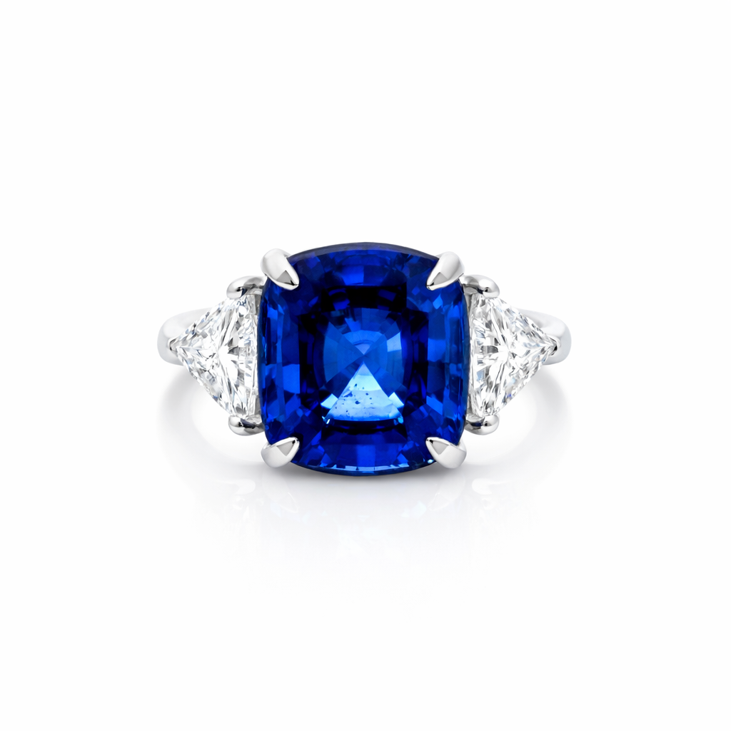 A silver ring with a large rectangular blue gemstone flanked by two smaller clear gemstones on either side.