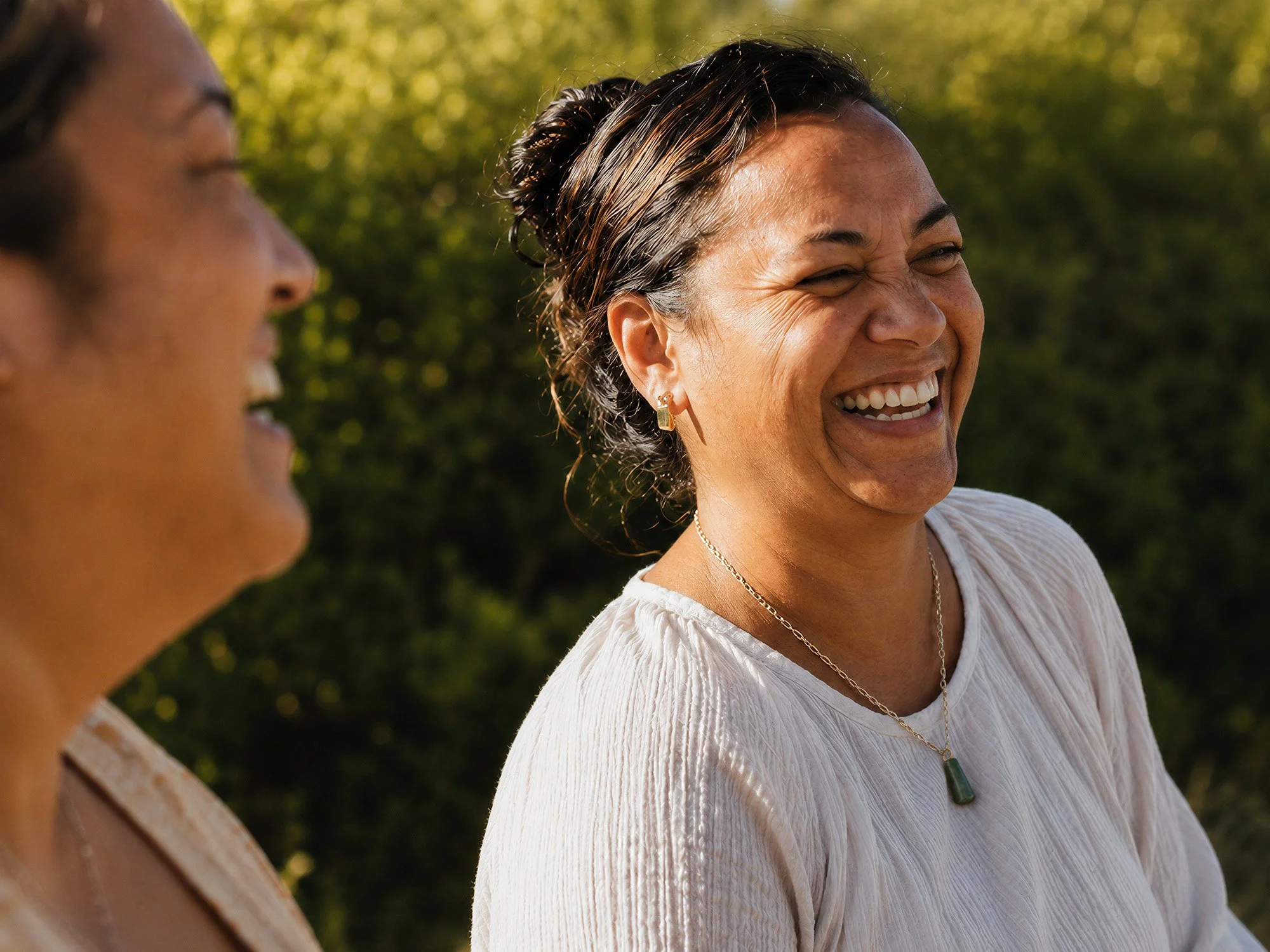 Two women smiling and laughing outdoors. We provide cervical screening in a calm, professional setting with clear information and patient support across the Wellington region.